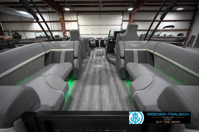 Slide: The Image of 2026 Bennington 24 MFB pontoon boat interior with gray seating and green LED lighting. - 18
