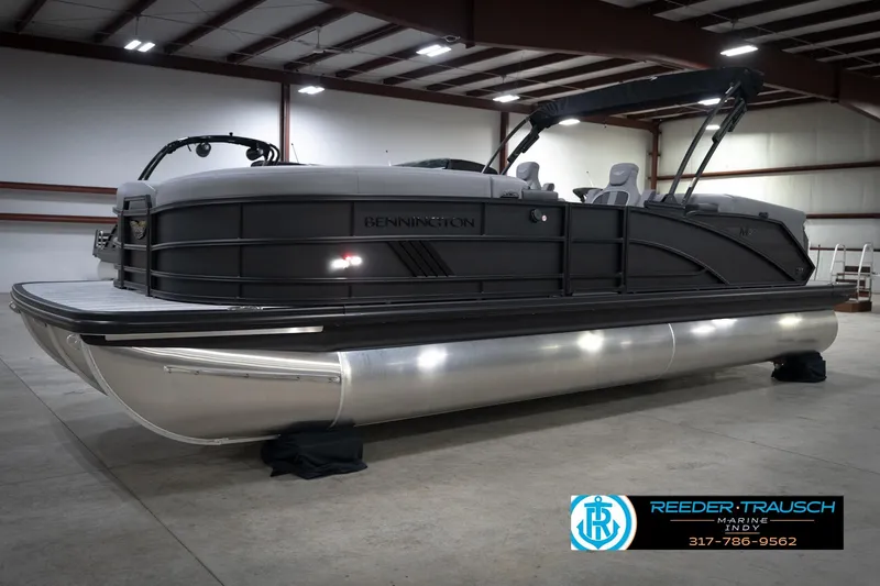 Slide: The Image of 2026 Bennington 24 MFB pontoon boat in a showroom with canopy and seating. - 2