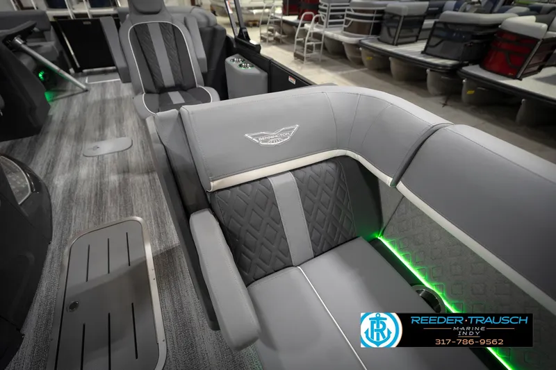 Slide: The Image of 2026 Bennington 24 MFB boat interior with modern seating and ambient lighting in a showroom. - 24