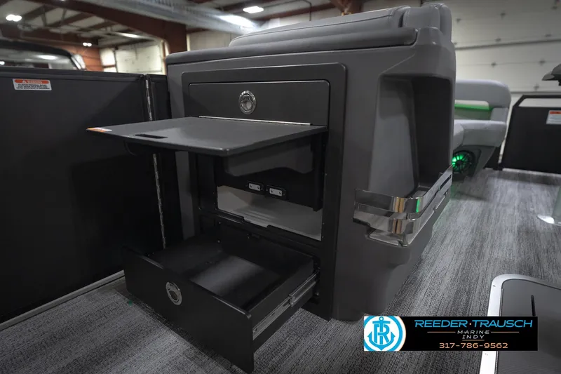 Slide: The Image of 2026 Bennington 24 MFB boat interior with gray seating and green LED lighting. - 29