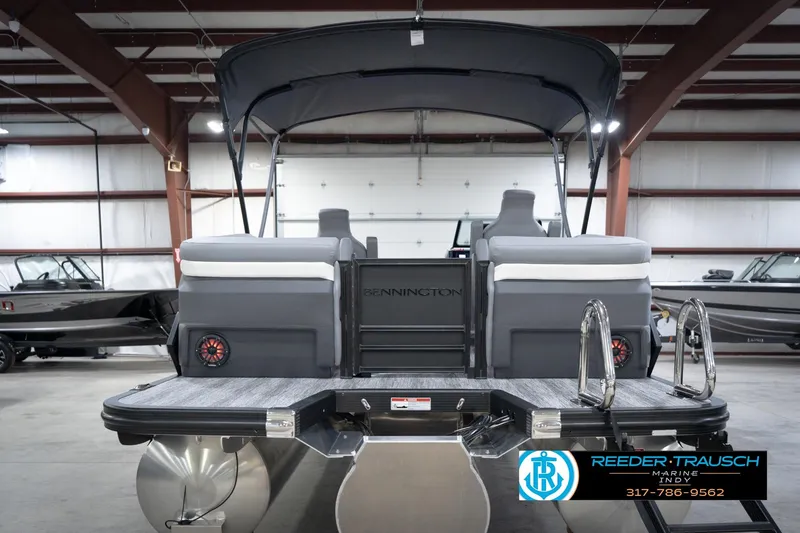 Slide: The Image of 2026 Bennington 24 MFB pontoon boat in showroom, rear view with seating and ladder. - 62