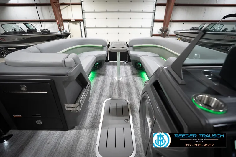 Slide: The Image of 2026 Bennington 24 MFB boat interior with modern seating and ambient lighting in a showroom. - 73
