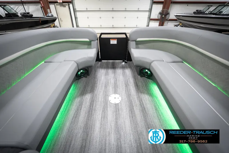 Slide: The Image of 2026 Bennington 24 MFB boat interior with gray seating and green LED lighting. - 75