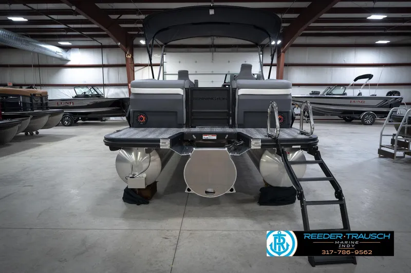 Slide: The Image of 2026 Bennington 24 MFB pontoon boat in showroom with canopy and ladder. - 8