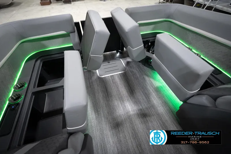 Slide: The Image of Interior of 2026 Bennington 24 MFB boat with green LED lighting and gray seating. - 80