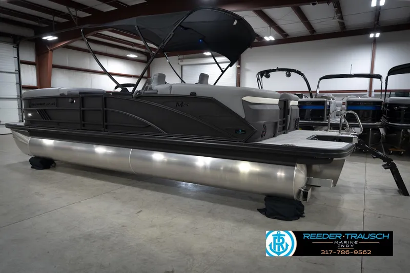 Slide: The Image of 2026 Bennington 24 MFB pontoon boat in showroom, rear view with seating and ladder. - 9