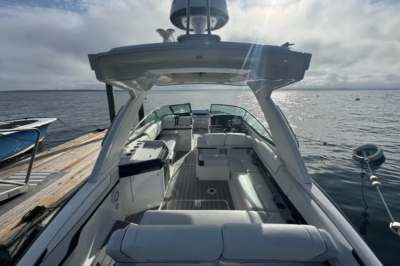 Slide: The Image of 2022 Formula 310 Bowrider OB boat docked, featuring spacious seating and modern design. - 2