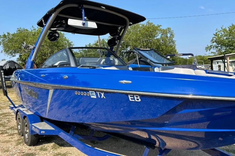 Slide: The Image of 2017 Malibu Wakesetter 25 LSV boat in vibrant blue on a trailer. - 11