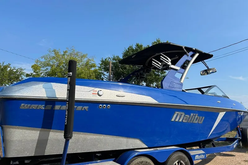 Slide: The Image of 2017 Malibu Wakesetter 25 LSV boat in vibrant blue, parked outdoors. - 14