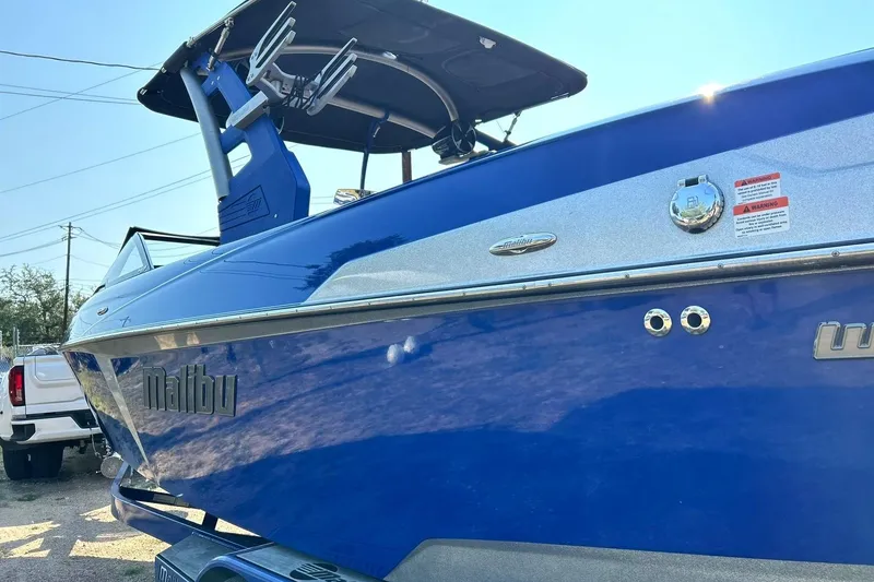 Slide: The Image of 2017 Malibu Wakesetter 25 LSV boat in vibrant blue, docked outdoors. - 21