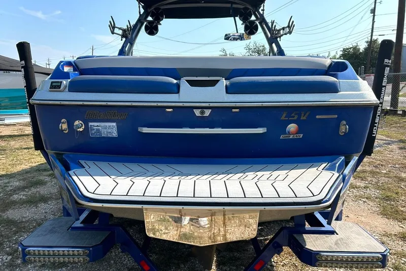 Slide: The Image of 2017 Malibu Wakesetter 25 LSV boat, blue exterior, rear view with swim platform. - 22