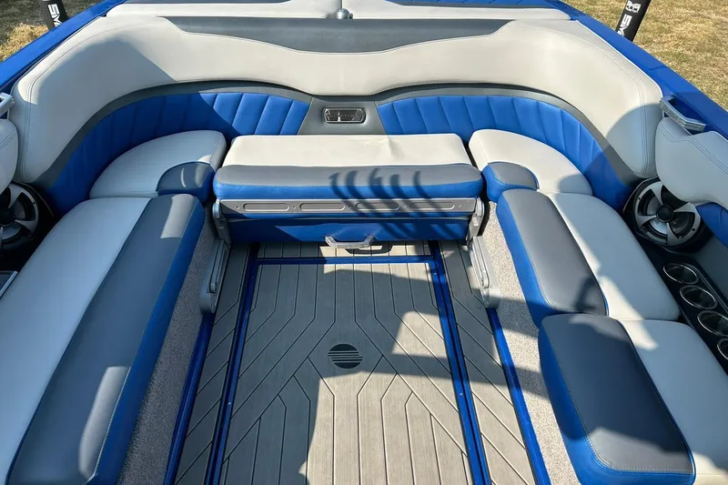 Slide: The Image of 2017 Malibu Wakesetter 25 LSV interior with blue and gray seating, cup holders, and speakers. - 32