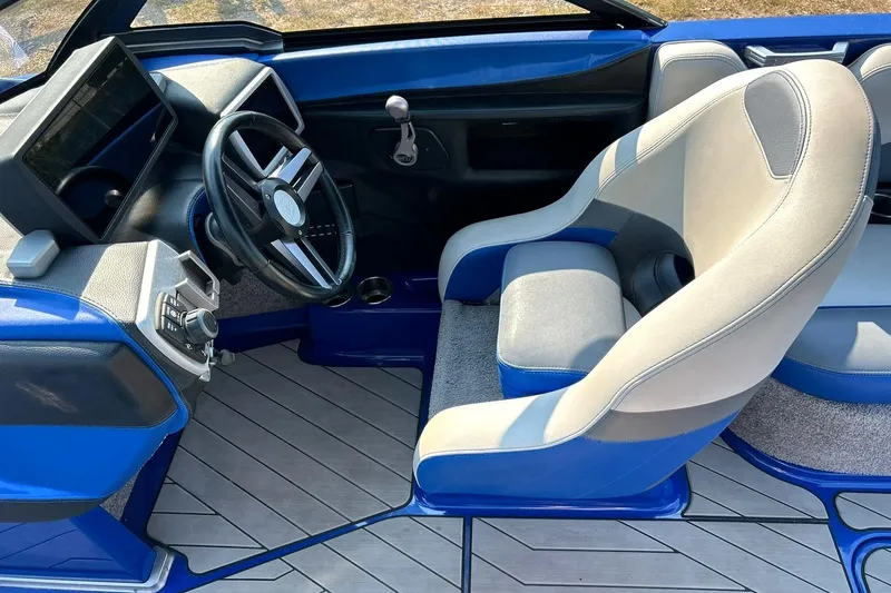 Slide: The Image of 2017 Malibu Wakesetter 25 LSV interior with blue and gray seating, modern dashboard, and steering wheel. - 39