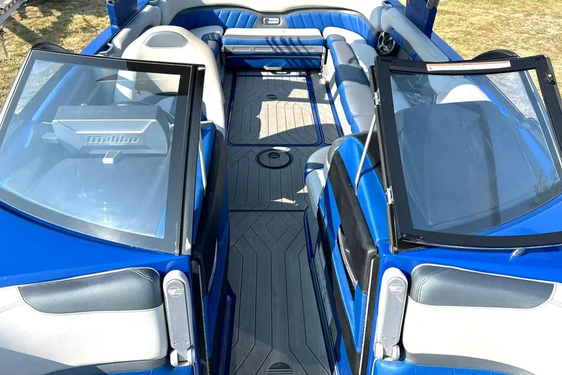 Slide: The Image of 2017 Malibu Wakesetter 25 LSV interior with blue and gray seating, open windshield. - 47