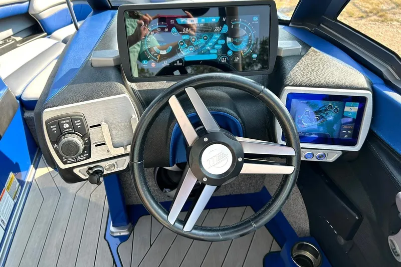 Slide: The Image of 2017 Malibu Wakesetter 25 LSV dashboard with modern touchscreen controls and steering wheel. - 5