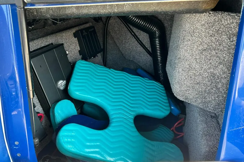 Slide: The Image of Storage compartment of 2017 Malibu Wakesetter 25 LSV with equipment and teal padding. - 59