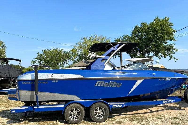 Slide: The Image of 2017 Malibu Wakesetter 25 LSV boat in vibrant blue on a trailer, parked outdoors. - 8