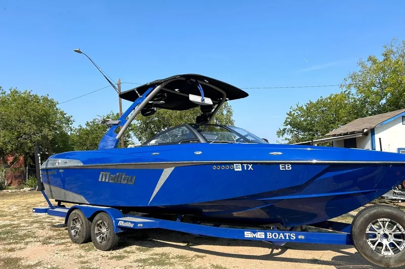 Slide: The Image of 2017 Malibu Wakesetter 25 LSV boat in vibrant blue on trailer, outdoors. - 9