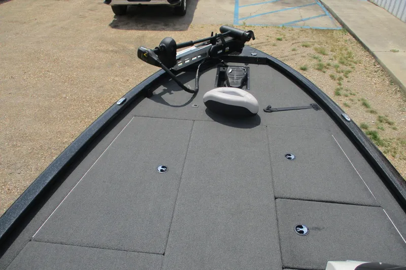 Slide: The Image of 2021 Avid 20XB boat deck with trolling motor and seating, parked on gravel. - 10