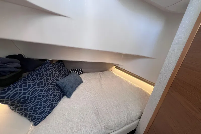 Slide: The Image of Cozy cabin interior of 2022 Tiara Yachts 34 LS with stylish bedding and ambient lighting. - 15