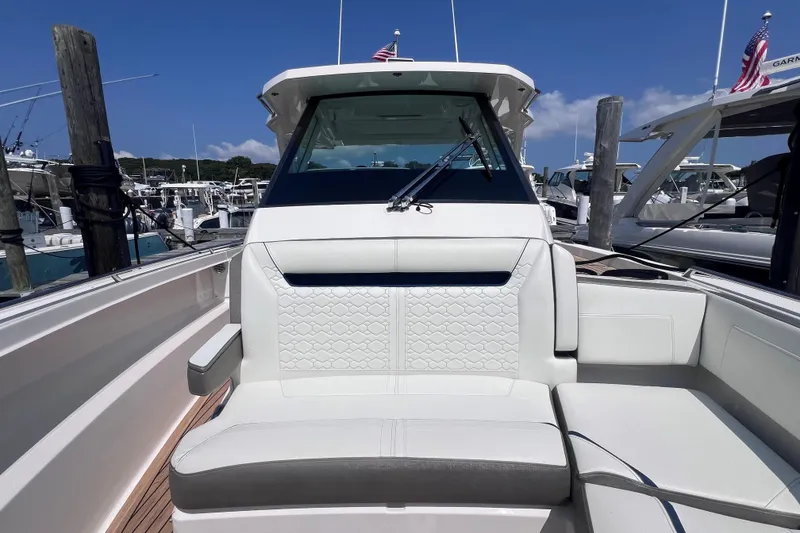 Slide: The Image of 2022 Tiara Yachts 34 LS luxury boat interior with white seating at marina. - 19