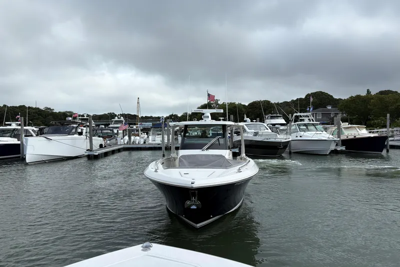 Slide: The Image of 2022 Tiara Yachts 34 LS in marina, surrounded by other boats under cloudy skies. - 22