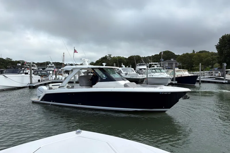 Slide: The Image of 2022 Tiara Yachts 34 LS in marina, overcast sky, surrounded by other boats. - 23