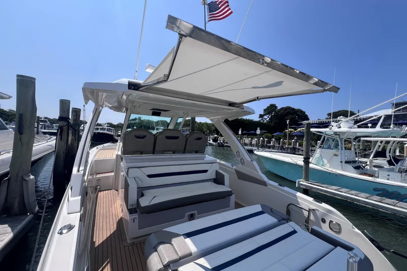 Slide: The Image of 2022 Tiara Yachts 34 LS luxury boat docked, featuring spacious seating and sunshade. - 5