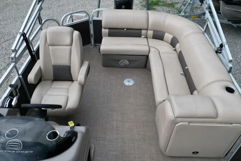 Slide: The Image of 2020 Sun Tracker Party Barge 20 DLX interior with beige seating and steering console. - 12
