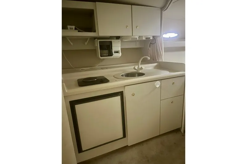 Slide: The Image of 1997 Cruisers Yachts 3075 Rogue kitchen with sink, stove, and storage cabinets. - 14