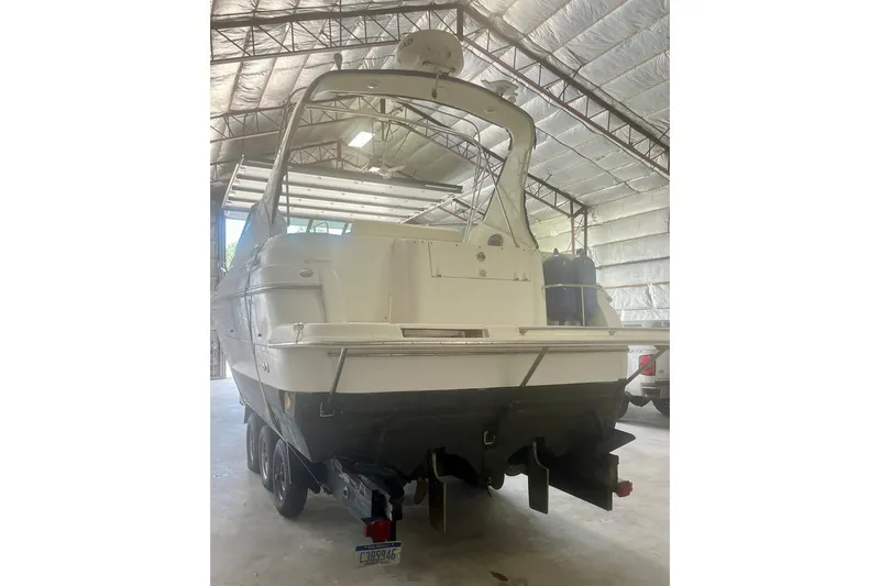 Slide: The Image of 1997 Cruisers Yachts 3075 Rogue in storage, rear view, under metal roof. - 3