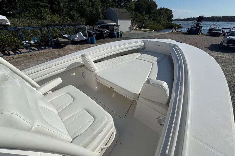 Slide: The Image of 2017 Regulator 28 boat with white seating and spacious deck near a waterfront. - 13