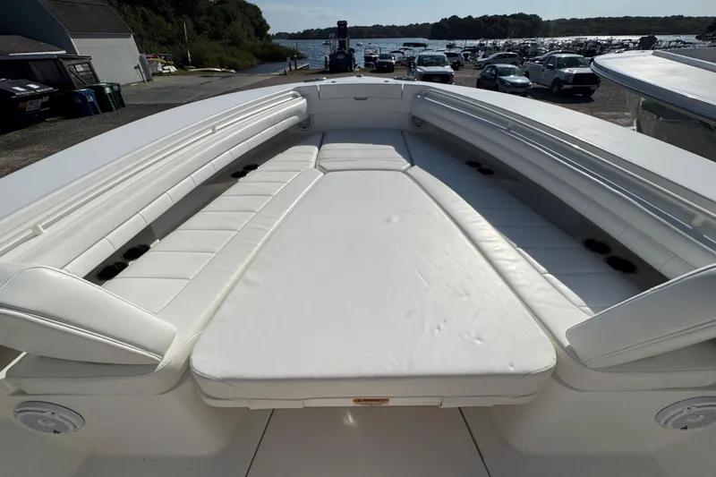 Slide: The Image of 2017 Regulator 28 boat with spacious white seating and cup holders, docked near water. - 15