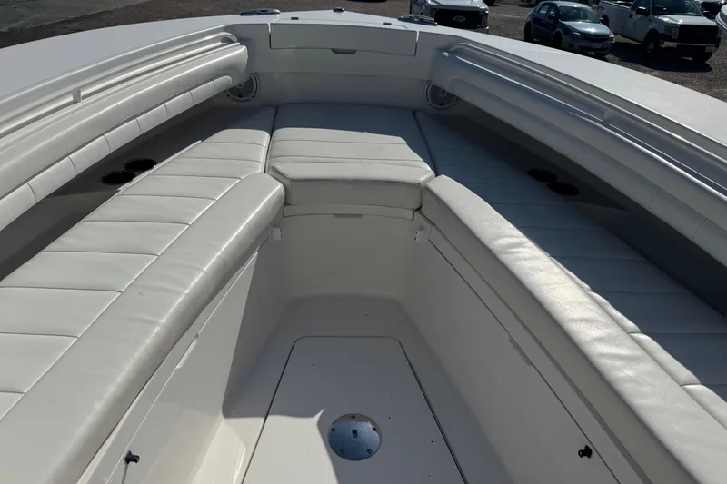 Slide: The Image of 2017 Regulator 28 boat interior with white cushioned seating and cup holders. - 19