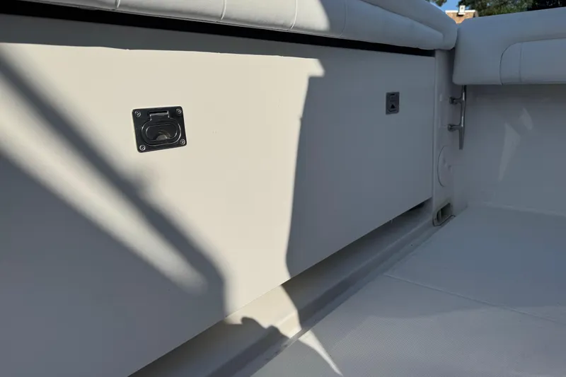 Slide: The Image of 2017 Regulator 28 boat interior with storage compartment and cushioned seating. - 21