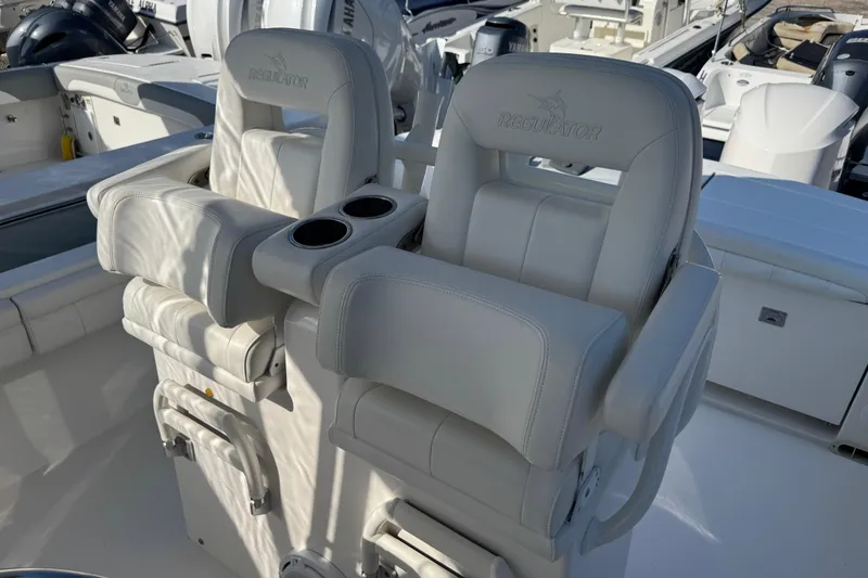 Slide: The Image of 2017 Regulator 28 boat with dual white cushioned seats and cup holders. - 24