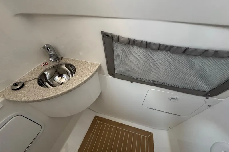 Slide: The Image of 2017 Regulator 28 boat interior with sink, faucet, and storage compartment. - 30