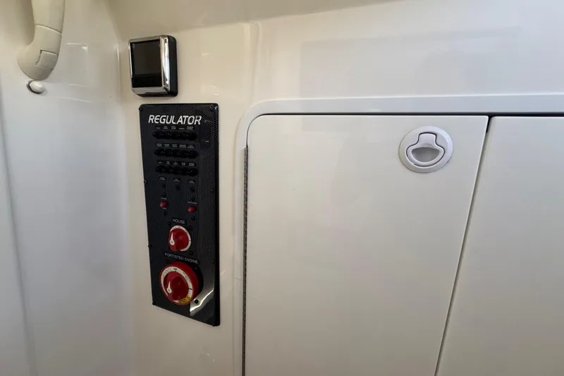 Slide: The Image of Control panel of a 2017 Regulator 28 boat with switches and knobs. - 34