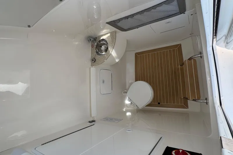 Slide: The Image of 2017 Regulator 28 boat interior with toilet, sink, and wooden flooring. - 35