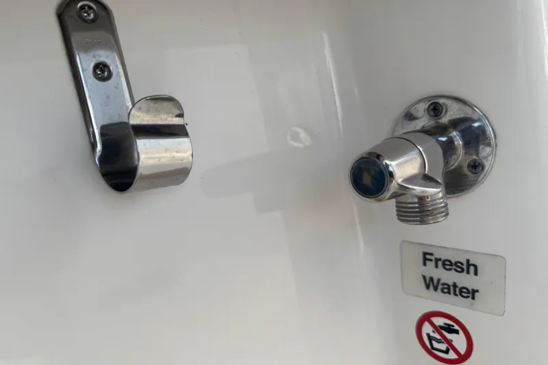 Slide: The Image of Fresh water outlet on 2017 Regulator 28 boat with metal hook and no-fuel symbol. - 36