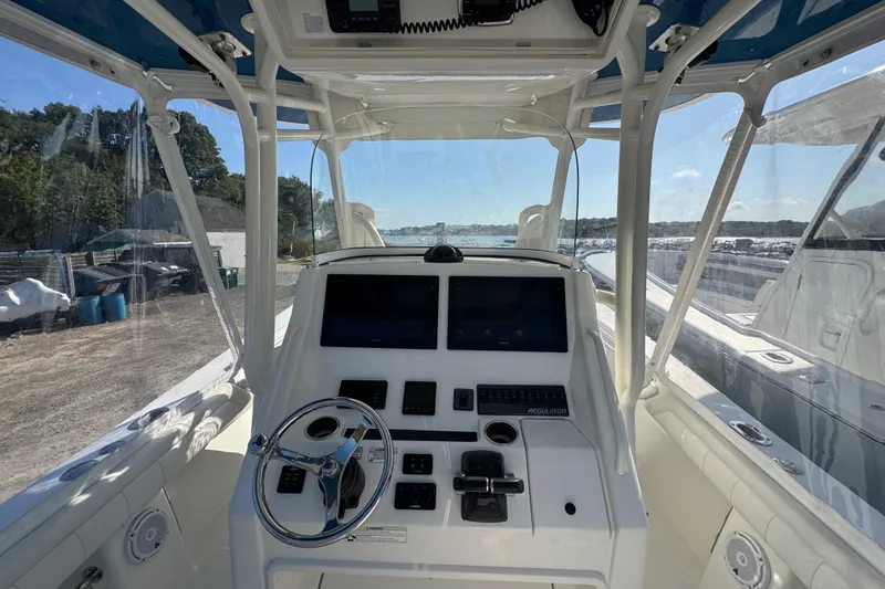 Slide: The Image of 2017 Regulator 28 boat cockpit with steering wheel and dual screens. - 38