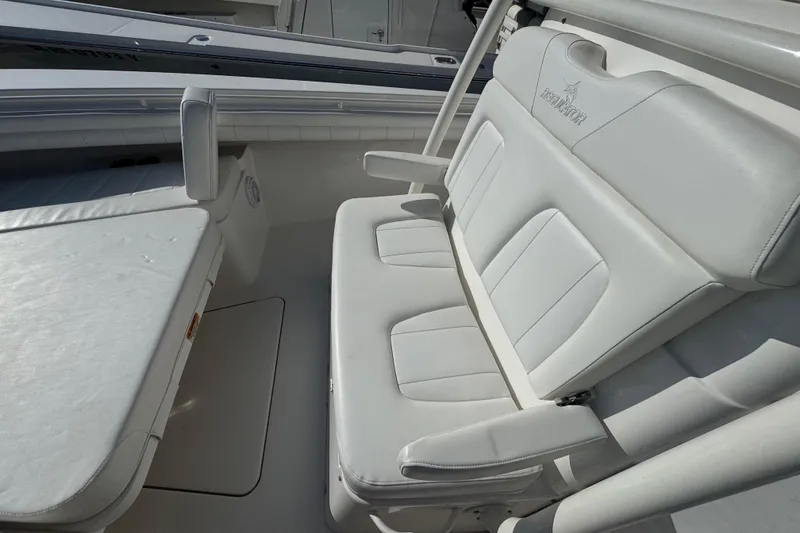 Slide: The Image of 2017 Regulator 28 boat interior with white cushioned seating and armrests. - 48