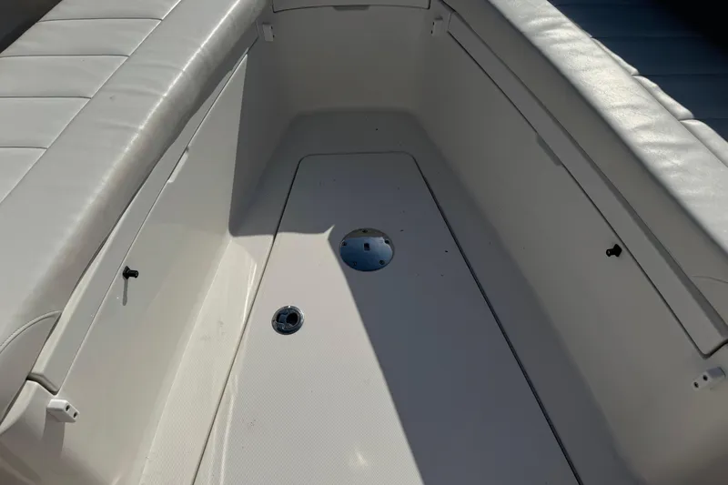 Slide: The Image of 2017 Regulator 28 boat interior with white seating and storage compartments. - 49
