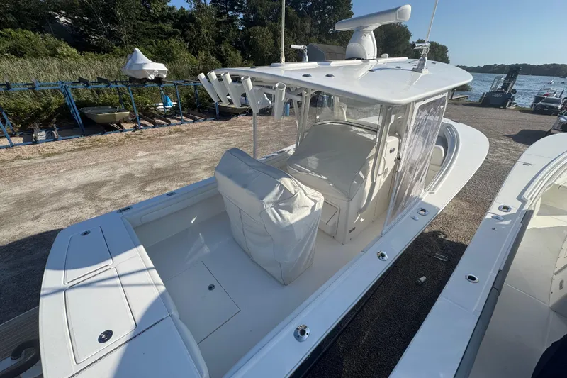 Slide: The Image of 2017 Regulator 28 boat with covered seating, docked near a scenic waterfront. - 52