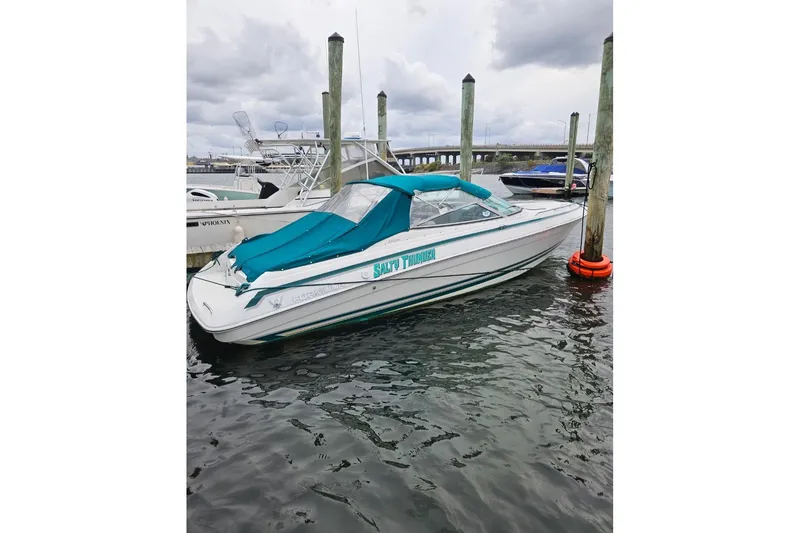 Slide: The Image of 1998 Formula 252 SS boat docked with teal cover, cloudy sky background. - 6