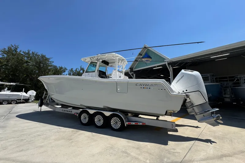 Slide: The Image of 2025 Caymas 34 CT boat on trailer, parked outdoors under clear blue sky. - 18