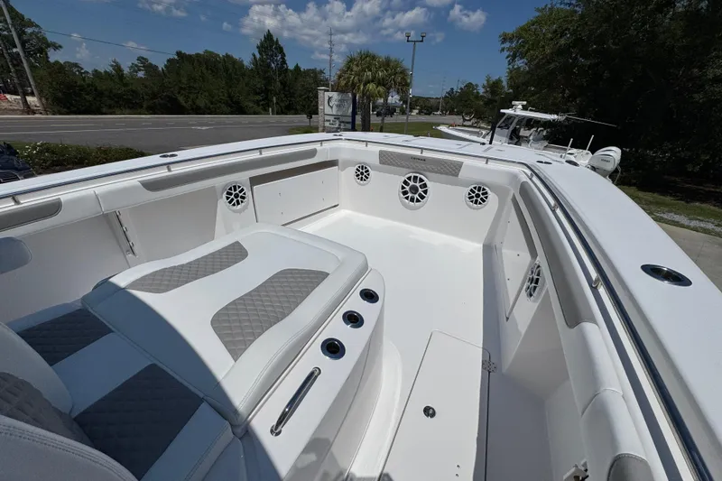 Slide: The Image of 2025 Caymas 34 CT boat interior with white seating and speakers, under a clear blue sky. - 21