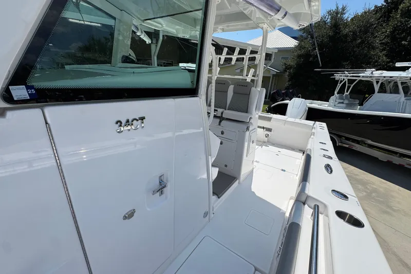 Slide: The Image of 2025 Caymas 34 CT boat, sleek white design, spacious deck, modern seating, outdoor setting. - 27