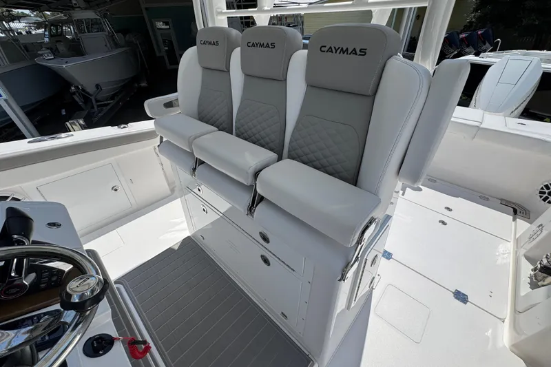 Slide: The Image of 2025 Caymas 34 CT boat interior with three cushioned seats and steering wheel. - 29