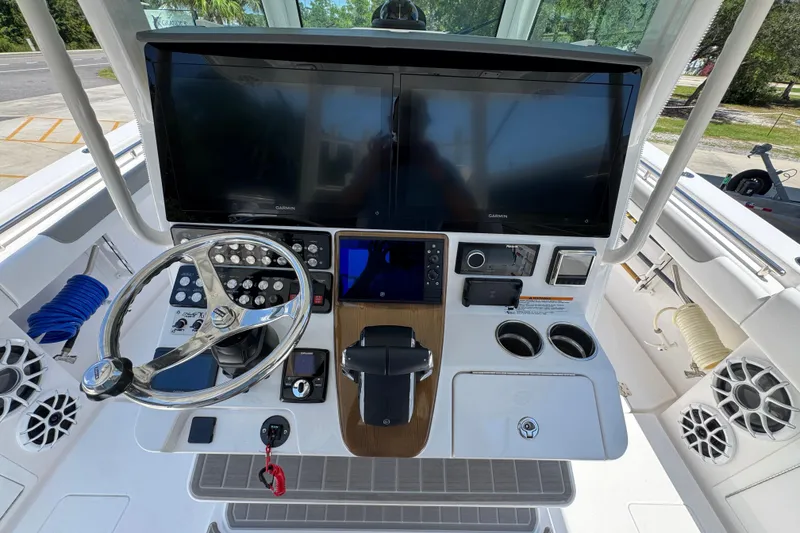 Slide: The Image of 2025 Caymas 34 CT boat dashboard with dual screens and steering wheel. - 33